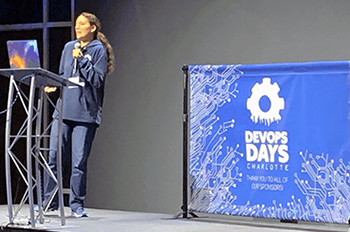 Devopsdays speaker Quintessence Anx on stage, giving her presentation